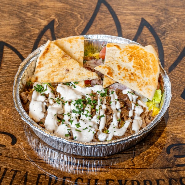 Pita Fresh Express Mediterranean bowl with meat, white sauce, parsley, and pita bread in a foil container.