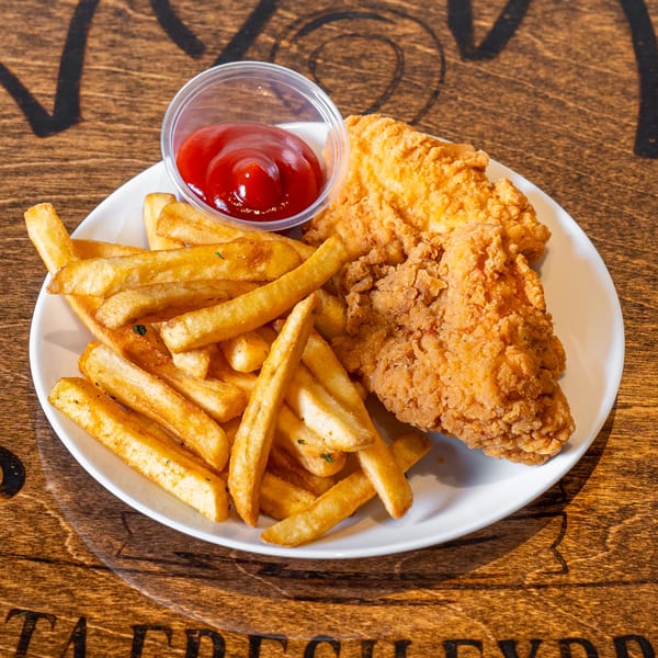 Crispy fried chicken tenders and golden french fries with a side of ketchup on a white plate.