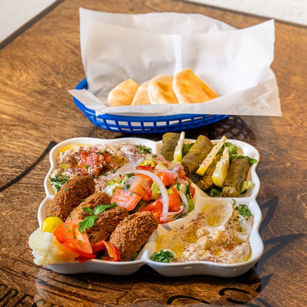 Pita Fresh Express Mediterranean platter with falafel, hummus, baba ghanoush, salad, and stuffed grape leaves.