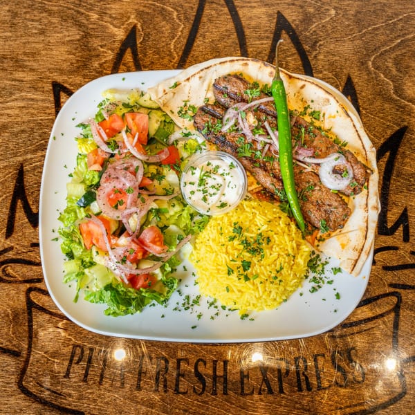 Pita Fresh Express Mediterranean platter with grilled meat, yellow rice, fresh salad, and pita bread.